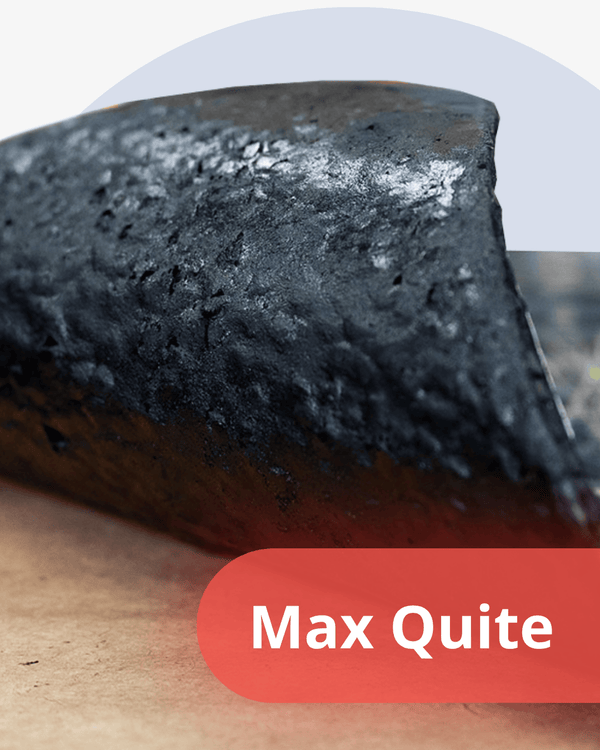 Close-up of a bar of black material with 'Max Quite' branding on a wooden surface.