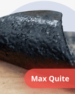 Close-up of a bar of black material with 'Max Quite' branding on a wooden surface.